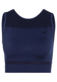 Námořnická sportovní podprsenka s mřížkovanou horní částí. Má přiléhavý střih, vycpanou podšívku a kontrastní tmavý pás na spodní části. Přítomné logo Nike.