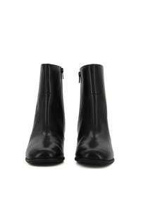 Stivaletti neri in pelle con una texture liscia, punta appuntita e cucitura centrale, dotati di cerniere laterali per la chiusura.