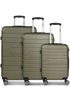 Three olive green hard-shell suitcases with white handles, featuring grooved designs and embossed "Bench." logo; mounted on spinner wheels.