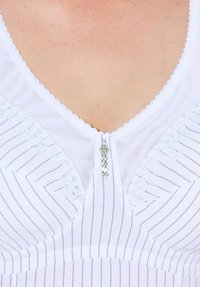 Garbamento bianco con sottili strisce verticali, dettagli in pizzo sul collo e una zip decorativa argento con accenti trasparenti.