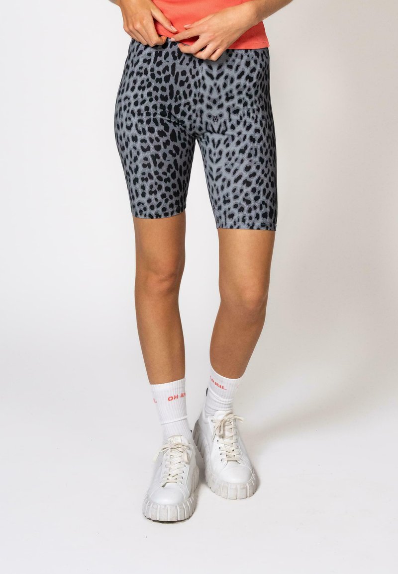 Shorts de cyclisme en tissu gris avec un motif léopard noir. Matériau extensible au toucher doux, ajusté près du corps.