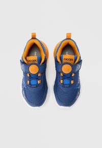 Blaue Sneaker mit orangefarbenen Akzenten, ausgestattet mit einem strukturierten Mesh-Obermaterial, Klettverschluss und einer gebogenen weißen Sohle. Geox-Logo auf der Zunge und der Seite.