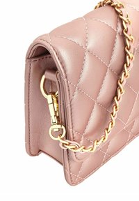 Kwiatowo różowa skórzana torebka z pikowaniem, z złotym łańcuszkiem i okuciami, z klapą zamykającą i widocznymi detalami stębnowania.