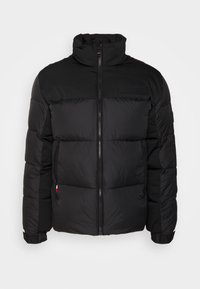 Veste matelassée noire avec col montant, fermeture éclair avant, poches latérales et logo de marque embossé subtil sur la poitrine.