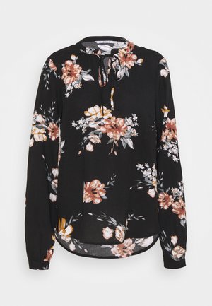 Blouse noire à fleurs avec manches longues, dotée d'un col rond et d'une fermeture à nouer. Le design comprend de grandes roses dans des teintes d'orange et de blanc.