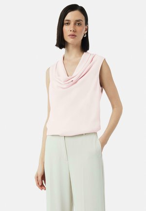 Sleeveless top in soft pink fabric with a draped cowl neckline, paired with light-green wide-leg trousers. Minimalist design, smooth texture.