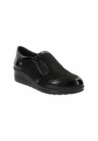 Scarpa nera slip-on con una toma superiore in rete testurizzata e dettagli in vernice lucida. Presenta un tacco a zeppa basso e dettagli con cerniera laterale.
