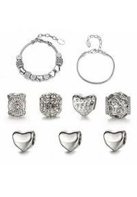 Braccialetti d'argento con charm decorativi e perline che presentano varie trame e forme, inclusi cuori ed elementi scintillanti.