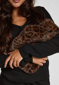 Brown leopard print faux fur accessory draped over a black long-sleeve top. Soft texture, rectangular shape with rounded edges.