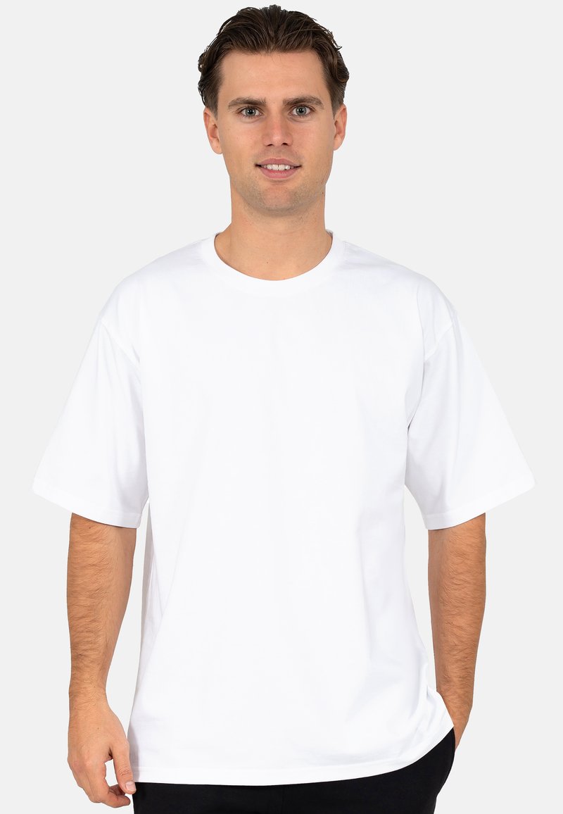 Witte katoenen T-shirt met korte mouwen, ronde hals, ontspannen pasvorm en een minimalistisch ontwerp. Gladde textuur en geen zichtbare patronen of graphics.