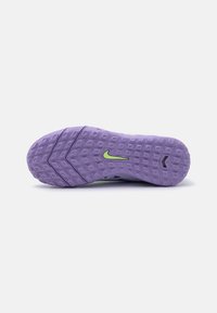 Suola in gomma viola con scanalature per trazione e il logo Nike verde. Superficie texturizzata per una buona presa, con un tallone curvo e un design angolare.