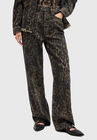 Crne traper široke hlače s smeškim leopard uzorkom. Imaju oštećen rub i bočne džepove. Uparene s crnim cipelicama na špic.