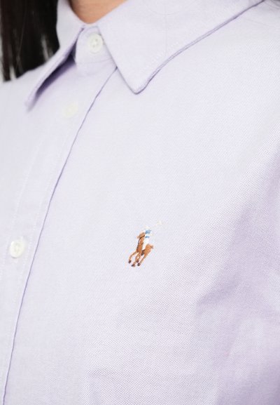 Jasnofioletowa koszula z kołnierzykiem wykonana z tkaniny o fakturze, z małym brązowym haftowanym koniem i jeźdźcem po lewej stronie.