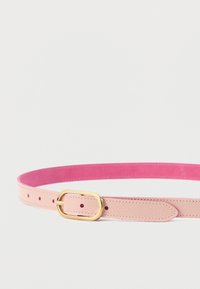 Φωτεινή ροζ δερμάτινη ζώνη με έντονα ροζ εσωτερική επένδυση και χρυσή οβάλ πόρπη, εμφανιζόμενη τυλιγμένη σε λευκό φόντο.