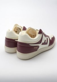 Skórzane sneakersy w kolorach bordowym i kremowym, z perforowaną częścią palcową, wyściełanym kołnierzem oraz wytłoczonymi detalami marki na pięcie.