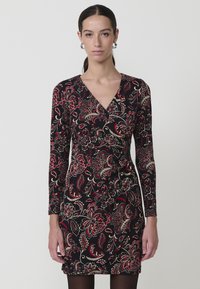 Vestido negro con mangas largas, con un patrón floral en rojo y dorado, diseño de escote en V y silueta ajustada. Textura de tela suave.