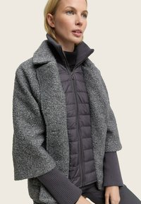 Grijze textuurjas met een puffer binnelaag, voorzien van een ritssluiting en geribde manchetten. Colbertontwerp met een relaxte pasvorm.