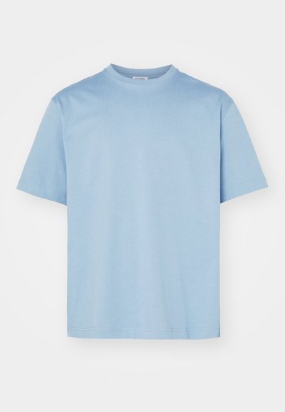 Camiseta de algodón azul claro con mangas cortas, un clásico cuello redondo y una textura suave. Diseño sencillo sin patrones ni adornos visibles.