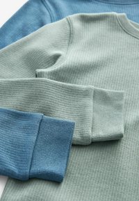 Zwei gestreifte Langarmoberteile, eines in Hellgrün und das andere in Blau, mit kontrastierenden strukturierten Bündchen und einem glatten Halsausschnitt.