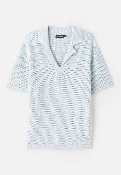 Polo de manga corta de punto azul claro con cuello en V y collar acanalado. Presenta un patrón texturizado de tejido abierto.