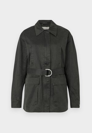 Chaqueta utilitaria de color verde oscuro, hecha de una mezcla de algodón, con collar puntiagudo, bolsillos frontales, cinturón con hebilla circular plateada y un corte relajado.