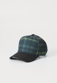 Casquette de baseball en tissu à carreaux vert foncé avec des accents jaunes, dotée d'une visière en suède noir et d'une sangle ajustable à l'arrière.