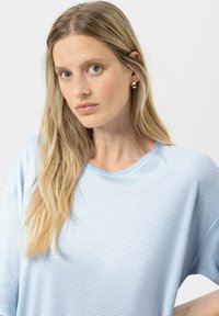 Jasnoniebieski t-shirt w paski wykonany z miękkiej tkaniny, z okrągłym dekoltem i krótkimi rękawami, o luźnym kroju i subtelnych detalach szycia.