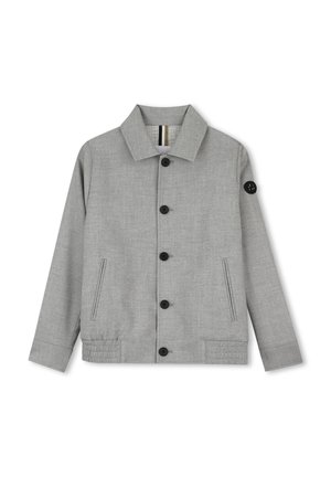 Veste gris clair boutonnée avec manches longues, deux poches latérales et un petit patch noir sur la partie supérieure gauche de la manche.