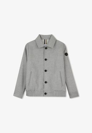 Veste gris clair boutonnée avec manches longues, deux poches latérales et un petit patch noir sur la partie supérieure gauche de la manche.