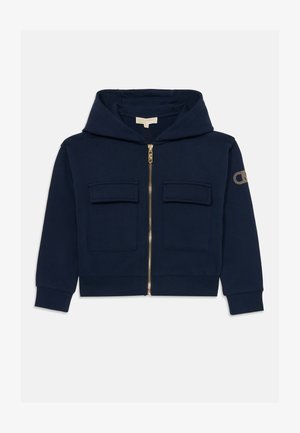 Sudadera azul marino con cremallera completa en la parte delantera, dos bolsillos en el pecho y puños acanalados. Adornada con un logo en la manga con detalles en dorado.