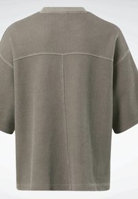 Boxové, krátké košile v tlumené zelené barvě s žebrovanou strukturou a jemným švem podél zad a ramen.