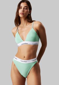 Mintgrønn bralette og høytlivede truser med hvit elastisk bånd som har "Calvin Klein" logo. Glatt, elastisk stoff med minimal design.
