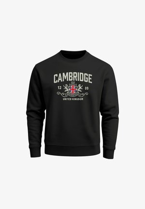 Black sweatshirt featuring "CAMBRIDGE" in bold white text, a circular emblem with a British flag, and decorative elements below.
