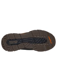 Skechers spordijalanõude talla must ja pruun kummidisain erinevate tekstuurimustritega ning bränding "GOODYEAR" ja "STEADY GRIP".