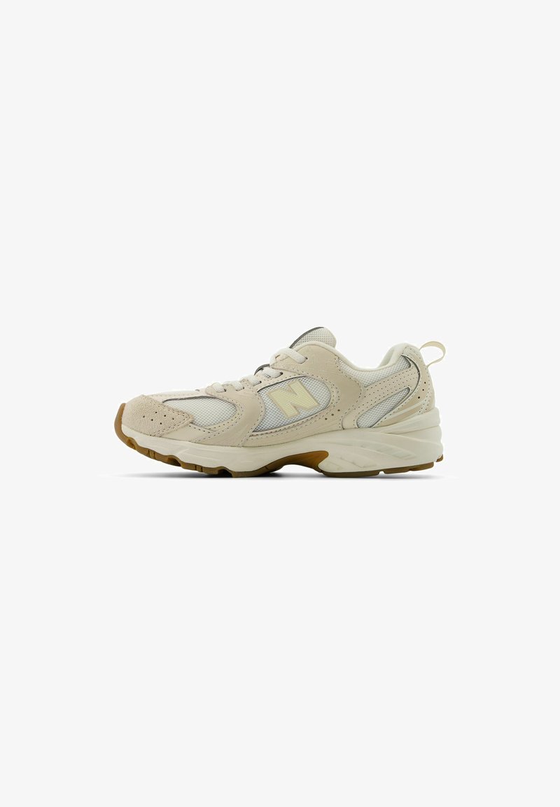 Scarpa da corsa beige con tomaia in rete e suede, punta arrotondata, suola ammortizzata e logo distintivo sul lato in un accento giallo chiaro.