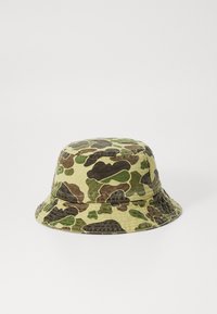 Green and brown camo bucket hat made of soft fabric, featuring a wide, downturned brim and stitched detailing along the edge.