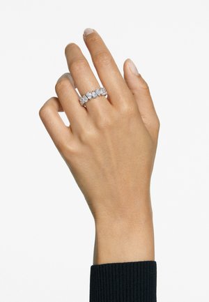 Künstlerischer Ring mit mehreren runden Steinen, eingefasst in ein elegantes Silberband, getragen an einer Hand mit einem strukturierten schwarzen Ärmels.