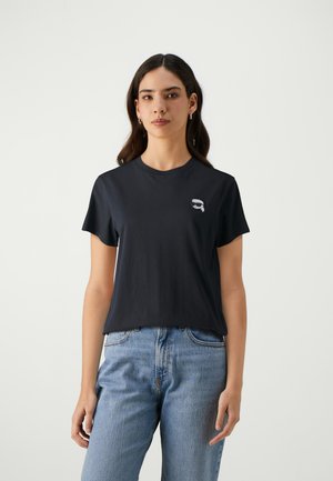 Black cotton t-shirt with short sleeves, round neckline, and a small graphic of a face wearing sunglasses on the left chest.