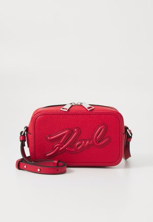 Rote Leder-Umhängetasche mit geprägt "Karl"-Logo, strukturierten Oberfläche, doppeltem Reißverschluss und verstellbarem Gurt.