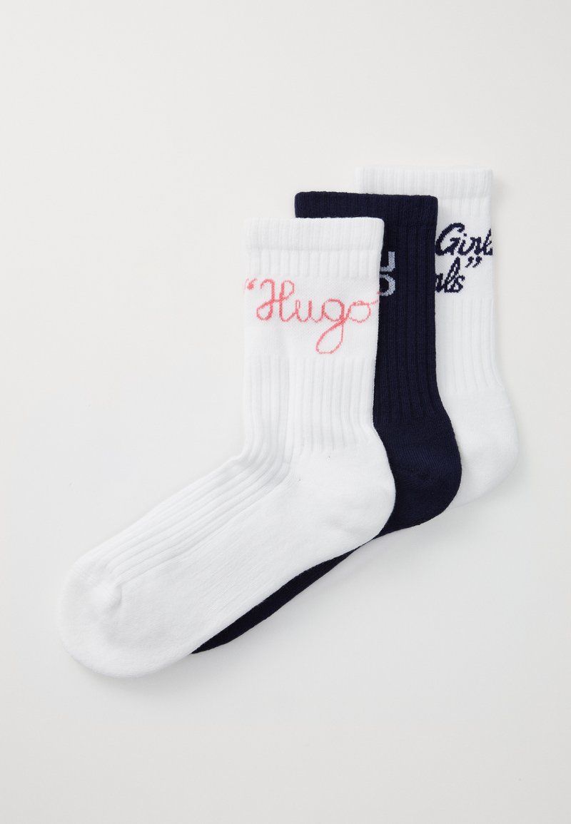 Tre par ankelsockar: ett par vita med rosa texten "Hugo", ett par vita med marinblå texten "Girls", och ett par helt marinblå. Ribbad struktur.