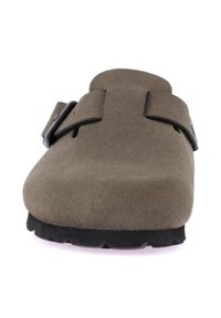 Scarpa slip-on in suede marrone con una punta ampia, due cinturini regolabili e una suola nera texturizzata. Presenta una forma arrotondata e un design minimal.
