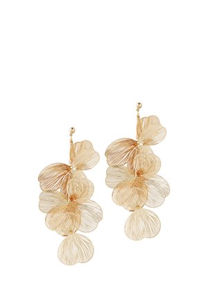 Boucles d'oreilles pendantes ton or avec des pétales délicats en ajouré superposés ressemblant à des fleurs, fixées à de petits clous ronds.