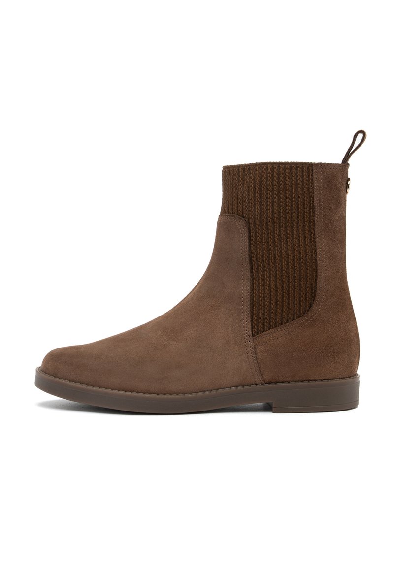 Botine din suede maro, cu panouri elastice laterale cu nervuri, vârf rotunjit și o bandă de prindere la toc. Tălpi din cauciuc plate, cusături minime.