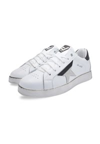 Białe sneakersy z teksturowaną gumową podeszwą, skórzaną cholewką i akcentem w czarno-srebrne gwiazdy. Zawierają sznurowadła i perforacje na palcach.