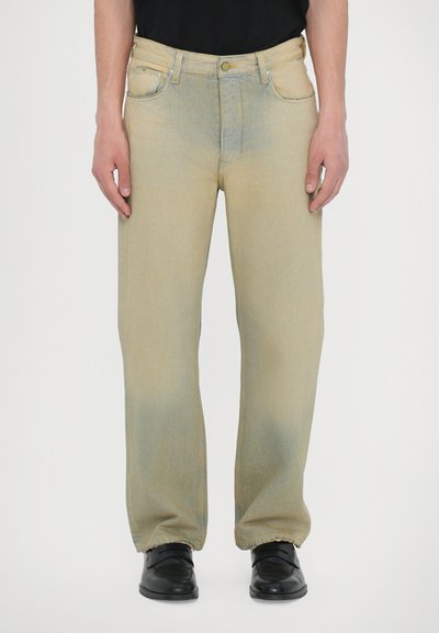 Lyseblå denim jeans med løs pasform, lige ben og frynser i kanten. Stofoverfladen har en falmet finish med subtile farvevariationer.
