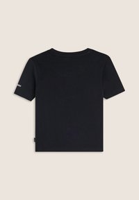 Camiseta negra de manga corta con un cuello redondo y un pequeño logo impreso en la manga izquierda. La tela parece suave y ligera.