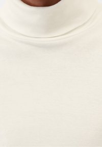 Weißer Rollkragenpullover aus weichem, strukturiertem Stoff mit hohem Kragen und glatter Oberfläche. Keine sichtbaren Muster oder Akzente.