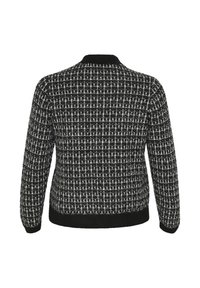 Schwarz-weiß gemusterter Cardigan mit strukturiertem Strickdesign, geripptem Kragen und Bündchen sowie einem enganliegenden schwarzen Bund am Saum.