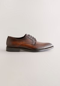 Chaussure habillée pour homme en cuir marron avec lacets, bout arrondi et petit talon sur fond clair neutre.