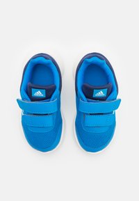 Niebieskie buty sportowe z siateczkową i syntetyczną cholewką, białą gumową podeszwą, dwoma zapięciami na rzep oraz niebieskim logo Adidasa na języku.